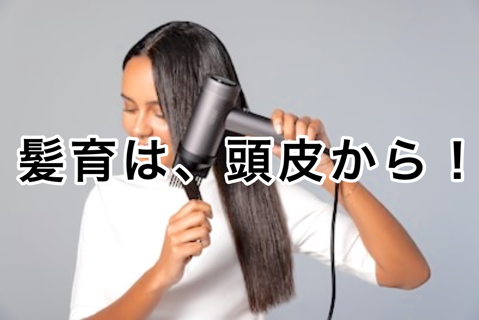 ドライヤーで髪をブロウする女性